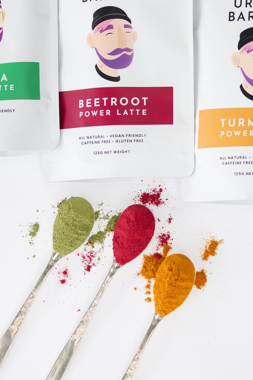 Three spoons with latte mix in them: matcha, turmeric and beetroot