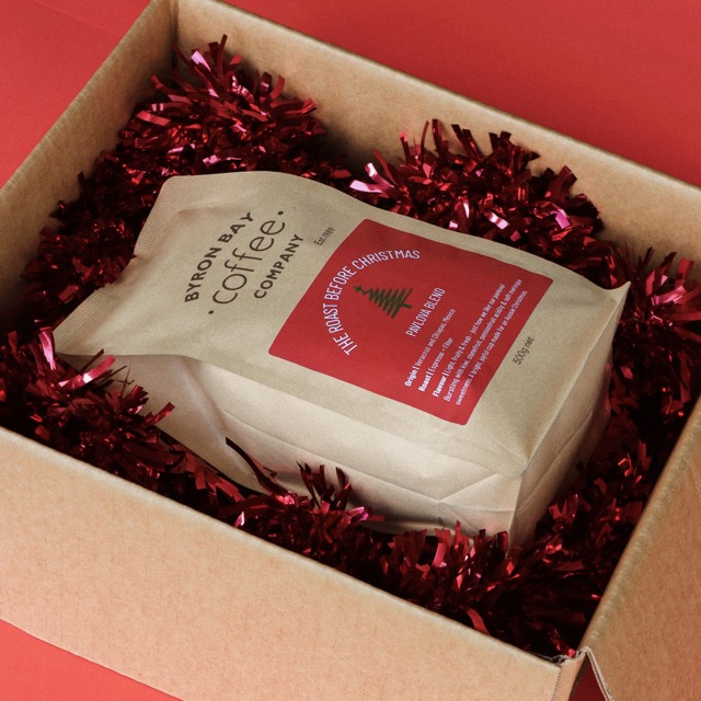 Cardboard box with Christmas decoration and a bag of coffee inside
